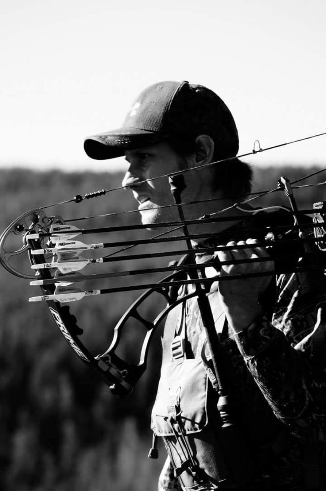 Black-and-white portrait of Christopher holding his bow