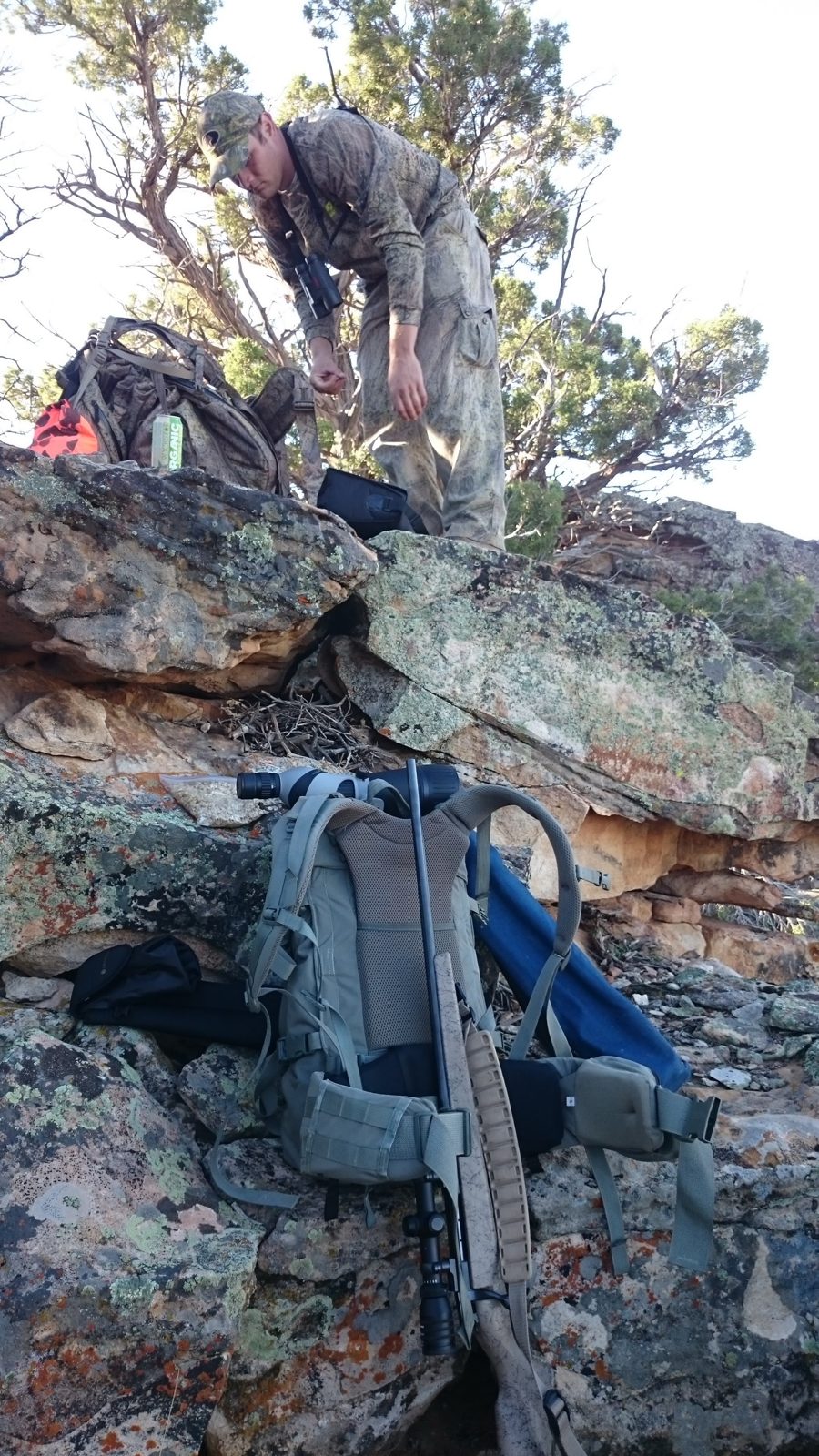 Christopher on rocky high country with his pack and rifle