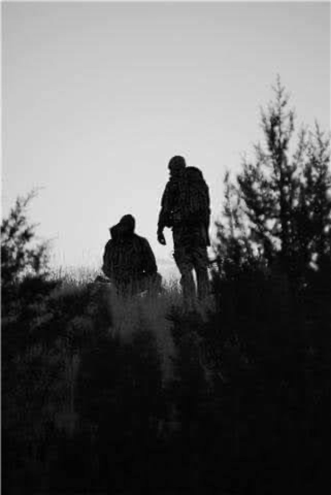 Black-and-white silhouette of two hunters